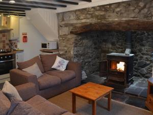 a living room with a couch and a fireplace at Dyserth in Clynnog-fawr