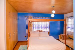 1 dormitorio con 1 cama con pared azul en Hope Homestay, en Syokimau