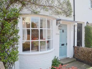 a white house with a blue door at Bow Cottage in Fordwich