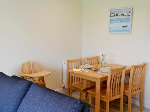 a dining room with a table and chairs and a bed at Freefolk Cottage in Polzeath