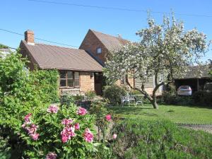 a house with a yard with pink flowers at Garden Cottage in Hasfield