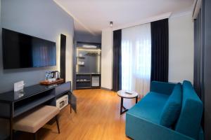 فندق بارين في إسطنبول: غرفة معيشة بها أريكة زرقاء وتلفزيون