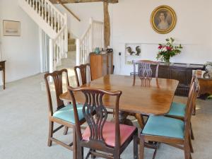 een eetkamer met een houten tafel en stoelen bij Red Lion Corner in Lavenham