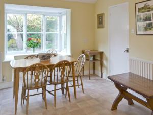 een eetkamer met een tafel en stoelen en een raam bij Red Lion Corner in Lavenham