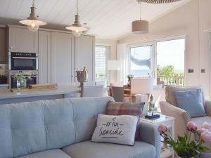 un soggiorno con divano blu e una cucina di Seatrees a Corton