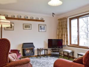 a living room with a fireplace and a tv at Shielgreen in Blairgowrie