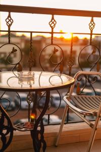 een tafel en 2 stoelen op een balkon bij Hôtel Lynx in Agadir