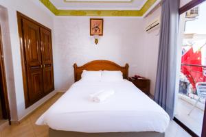 a bedroom with a bed and a large window at Hôtel Lynx in Agadir