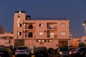 un bâtiment avec des voitures garées devant lui dans l'établissement Hôtel Lynx, à Agadir