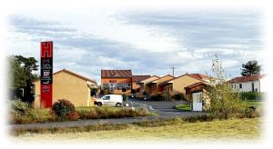 a sign in a residential neighborhood with houses at Hôtel Cantal Cottages in Saint-Georges