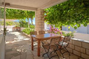 a wooden table and chairs on a patio at Pansion Marjan in Zavala
