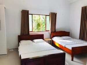two beds in a room with a window at SUNNY Homestay Mui Ne in Phan Thiet +37 photos