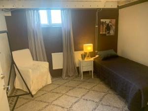 ein Schlafzimmer mit einem Bett, einem Stuhl und einem Fenster in der Unterkunft Örgryte centralt in Göteborg