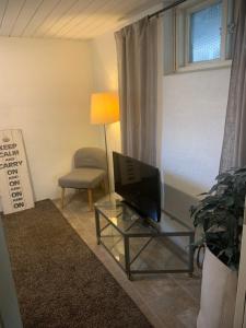 ein Wohnzimmer mit einem TV und einem Stuhl in der Unterkunft Örgryte centralt in Göteborg