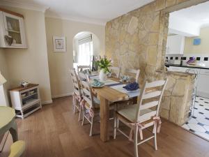 a kitchen and dining room with a wooden table and chairs at The Retreat Lulworth in West Lulworth