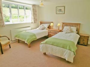 een slaapkamer met 2 bedden, een stoel en een raam bij Purcombe Farmhouse - 28458 in Whitchurch Canonicorum