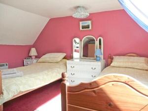 a bedroom with two beds and a mirror at The White House in Pitlochry
