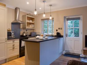a kitchen with a large island in the middle at The Coach House in Tattingstone