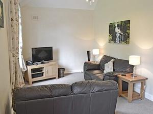 uma sala de estar com um sofá e uma televisão em Levans Cottage em Lindale