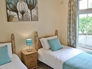 a bedroom with two twin beds and a window at Levans Cottage in Lindale