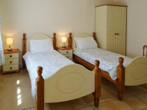 two twin beds in a room with two lamps at Meadow View in Leiston