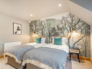 two beds in a bedroom with a painting on the wall at Hill View in Dalbeattie