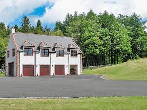 a white house with red doors and a driveway at Hill View in Dalbeattie