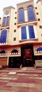 a building with blue windows and a door at فندق النيم in Al ‘Awālī