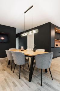 a dining room with a wooden table and chairs at Skylark - Stockholm Penthouse with Jacuzzi, Movie Theater & Panoramic View in Braşov +35 photos