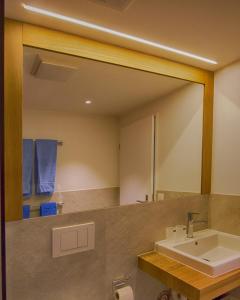 a bathroom with a large mirror and a sink at Residence Bellevue in Zermatt