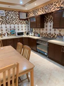 a kitchen with wooden cabinets and a table and chairs at شقه مفروشه للايجار اليومي in Mecca