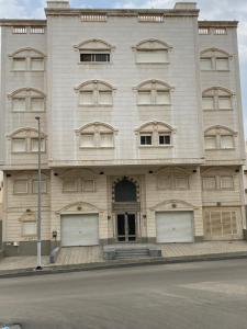 a large white building with three garages at شقه مفروشه للايجار اليومي in Makkah