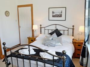 a bedroom with a bed with pillows on it at Winloma in Port William