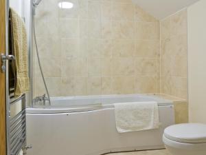 ein Badezimmer mit einer weißen Badewanne und einem WC in der Unterkunft Hare Lodge in Lamerton