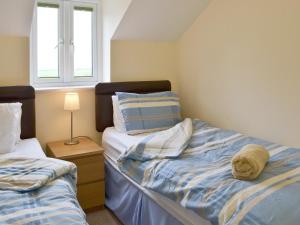 ein Schlafzimmer mit 2 Betten und einem ausgestopften Tier auf dem Bett in der Unterkunft Hare Lodge in Lamerton