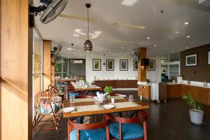 a restaurant with tables and chairs in a room at Haze and Kites Resort Munnar in Munnar