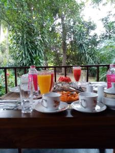 einen Holztisch mit Getränken und Speisen darauf in der Unterkunft Oasis Safari Cottage in Udawalawe + 48 Fotos