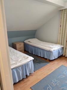 Habitación con 2 camas y alfombra azul en Marent Apartments, en Salo