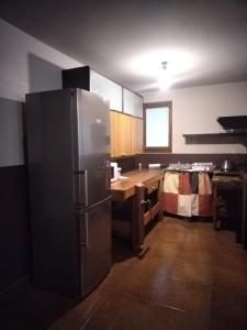 uma cozinha com um frigorífico de aço inoxidável e uma mesa em Soggiorno Via del golf 41 em Carimate