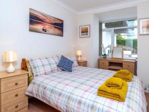 a bedroom with a bed and a desk and a window at 7 Vista Apartments in Paignton