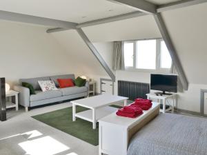 a living room with a couch and a tv at Turnstone Cottage in Sheringham