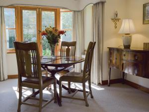 a dining room table with chairs and a vase of flowers at Russet Cottage in Moreton in Marsh