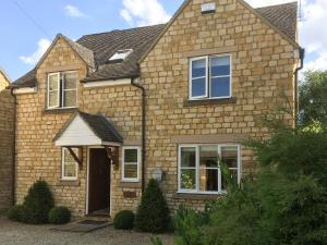 a brick house with white windows at Russet Cottage in Moreton in Marsh