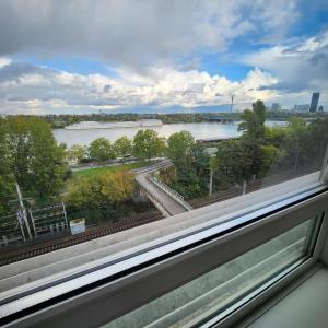 een raam met uitzicht op een rivier bij Lovely Apartment for 4 on the Danube River - Private Parking in Wenen