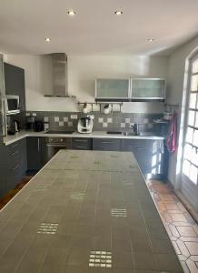 a kitchen with blue cabinets and a tile floor at Foix Villa 150m2 dans très grand parc arboré in Foix