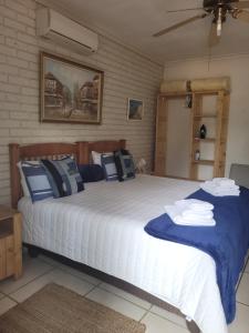 een slaapkamer met 2 bedden met blauwe en witte kussens bij De Heide Guesthouse in Bothaville