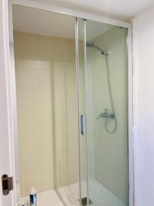 a shower with a glass door in a bathroom at Hostel Baqueira - Refugi Rosta - PyrenMuseu in Salardú