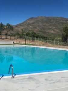 a large swimming pool with a mountain in the background at Casa da Pipela 