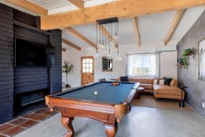a living room with a pool table and a fireplace at 2 Min To Dt, Fire Pit, Hot Tub, Fully Fenced in Joshua Tree