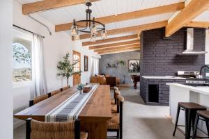 uma cozinha e sala de estar com uma mesa de madeira e uma lareira em 2 Min To Dt, Fully Fenced, Hot Tub, Plunge Pool em Joshua Tree